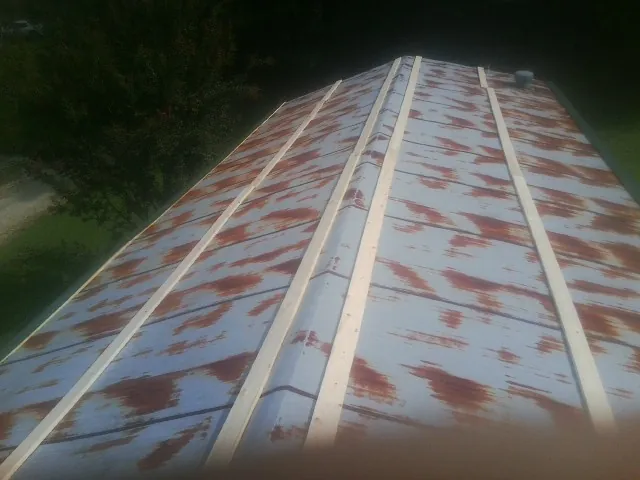 Rusted metal roof panels with new wood purlins before replacement — Storm Damage Roof Repair in Stryker by Roofing Brothers