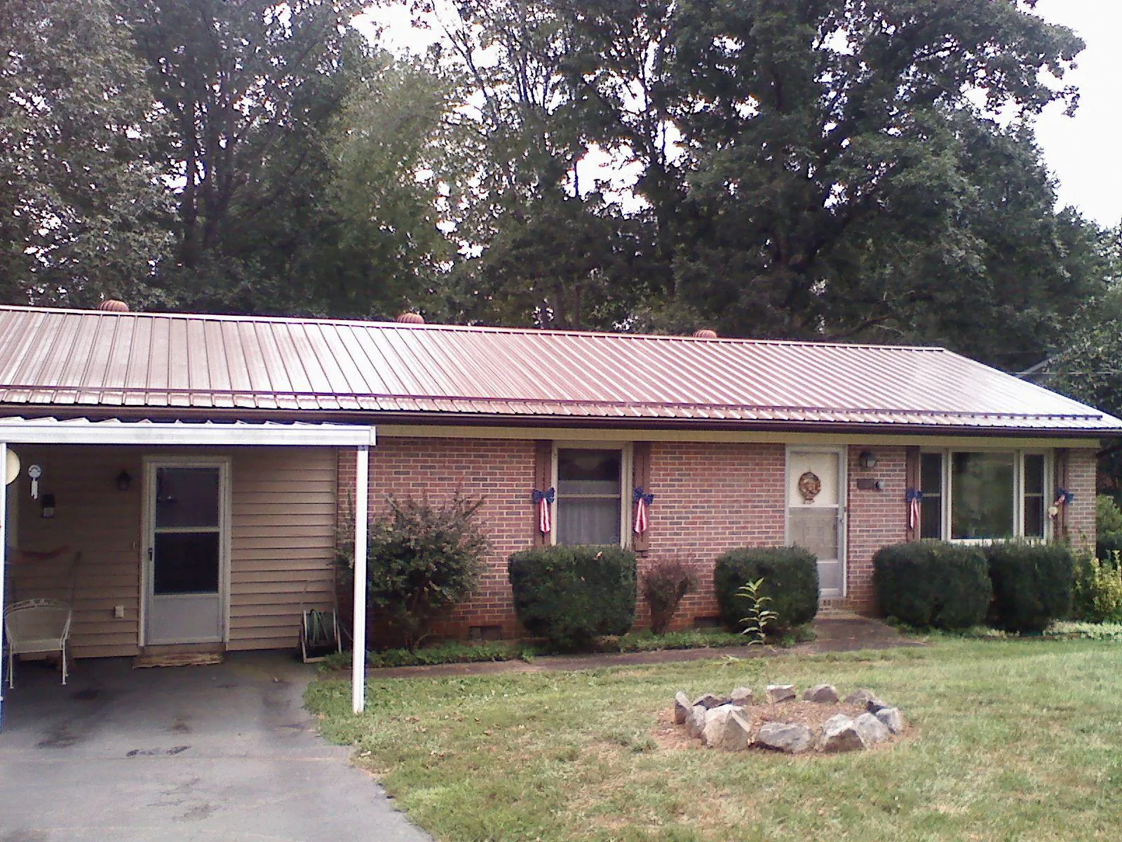Bronze metal roof and carport on a brick ranch home — Roof Repair work by our crew in Stryker